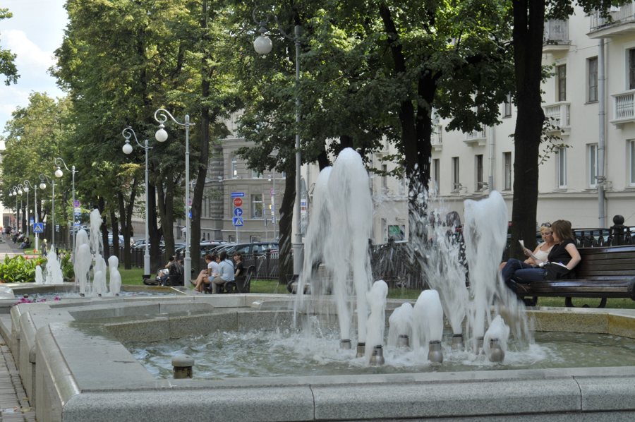 Фонтаны и скамейки среди деревьев в общественном пространстве Минска